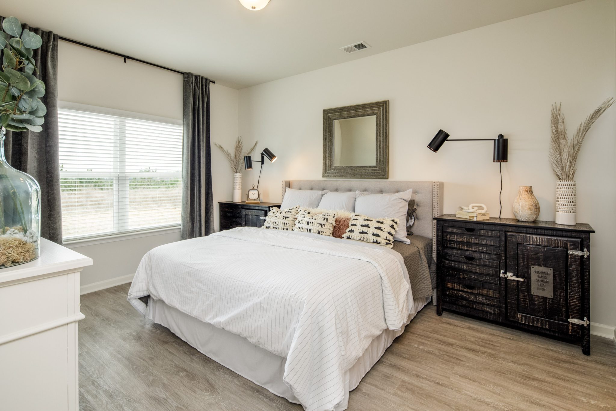 bedroom with queen sized bed and window in model home